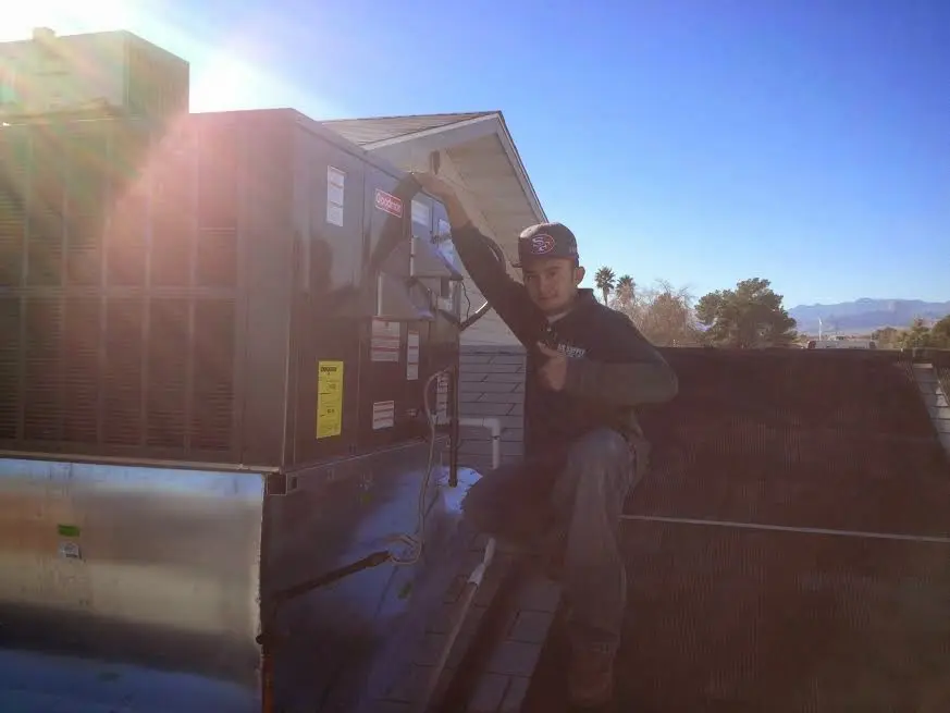 HVAC technician performing Boiler Repair on a rooftop unit in Granger